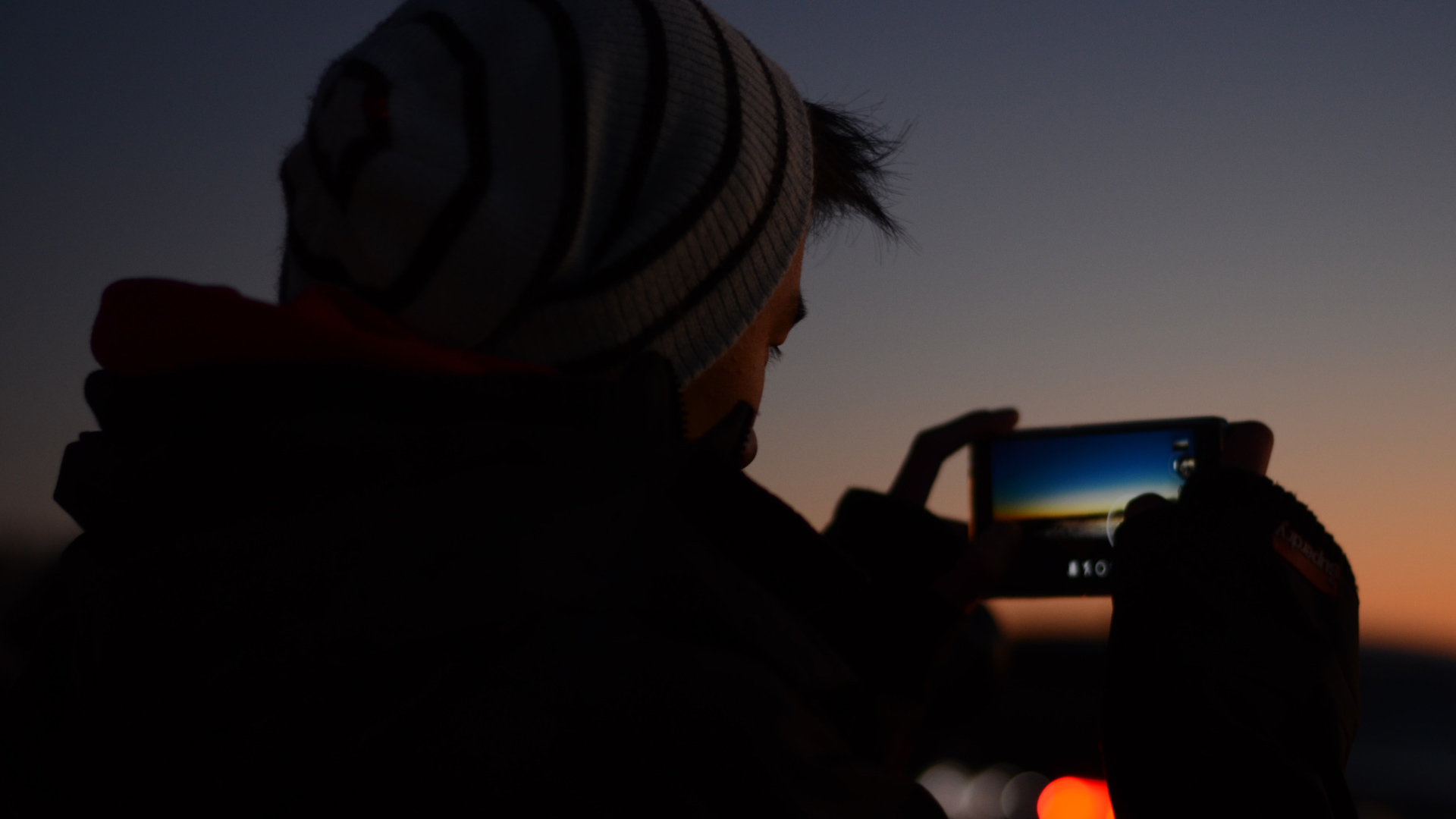 پسری در حال عکاسی در شب با موبایل